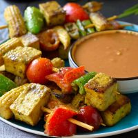This vegan satay with peanut sauce is easy to prepare and great served as party finger food. Mixed vegetables and tofu are marinated in a delicious Thai-style coconut milk marinade then fried until soft and crispy on the outside. Served with a tasty peanut and lime sauce on the side for dipping.