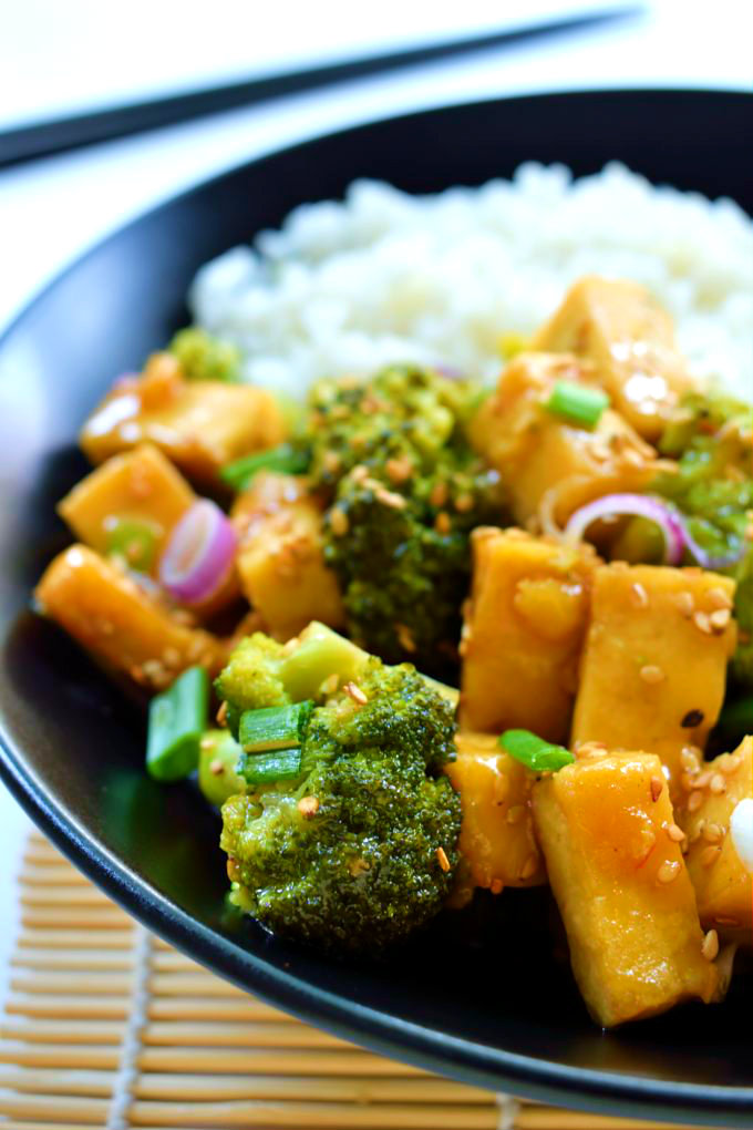 Orange and ginger glazed tofu is a quick and easy 30-minute weeknight meal. Crispy pan-fried tofu and fresh, crisp steamed broccoli in a sweet, ginger orange sauce. A healthy vegan/vegetarian meal. 