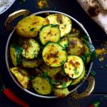 Este plato sencillo de patatas y calabacín con especias indias esta lleno de sabor! Dos ingredientes principales y un manojo de especias es todo lo que necesitas para este plato vegano o vegetariano. Se puede servir para acompañar otro plato o con arroz y naan o chapati.