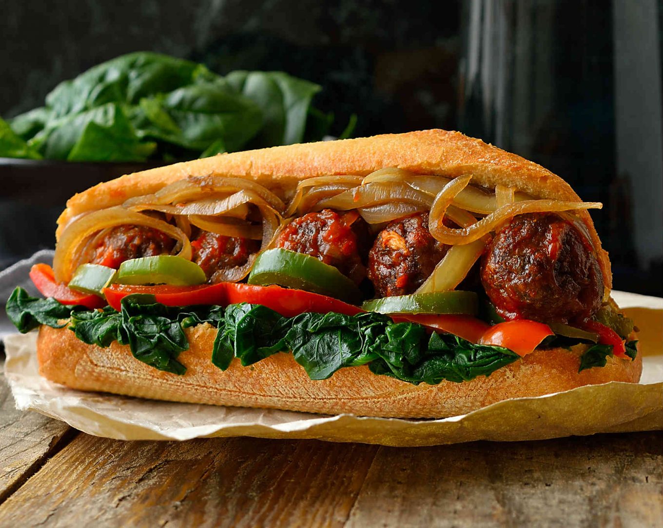 This vegan meatball sub sandwich is super hearty, super flavourful and chock full of veggies. Baked lentil and mushroom meatballs smothered in marinara sauce and served up in a crusty bun stuffed with spinach, onion and peppers. You might need a knife and fork to get these bad boys in your mouth!