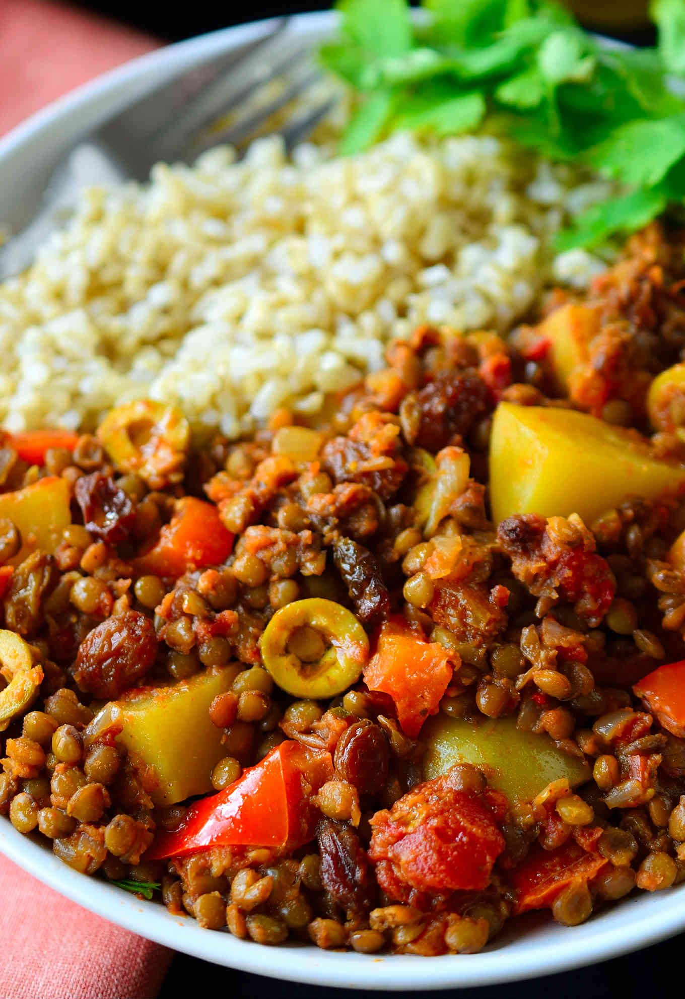 This vegan picadillo recipe is a delicious and colourful Cuban-style dish of spiced lentils, potatoes, tomatoes, olives and raisins. Served with rice, it’s quick and easy to prepare for a weeknight dinner and the warming spices of cinnamon, cumin, cloves and nutmeg make it a comforting and hearty meal for chilly weather. 