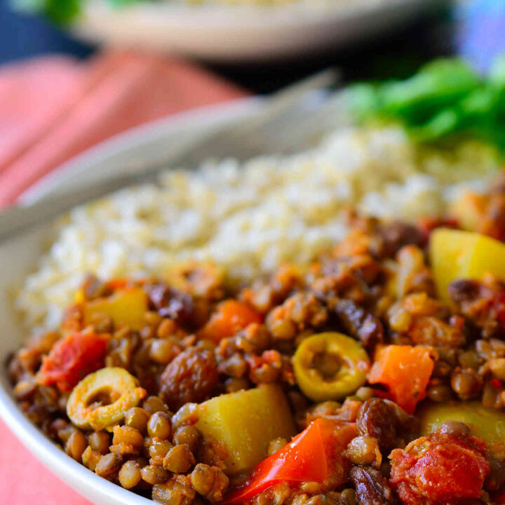 This vegan picadillo recipe is a delicious and colourful Cuban-style dish of spiced lentils, potatoes, tomatoes, olives and raisins. Served with rice, it’s quick and easy to prepare for a weeknight dinner and the warming spices of cinnamon, cumin, cloves and nutmeg make it a comforting and hearty meal for chilly weather.