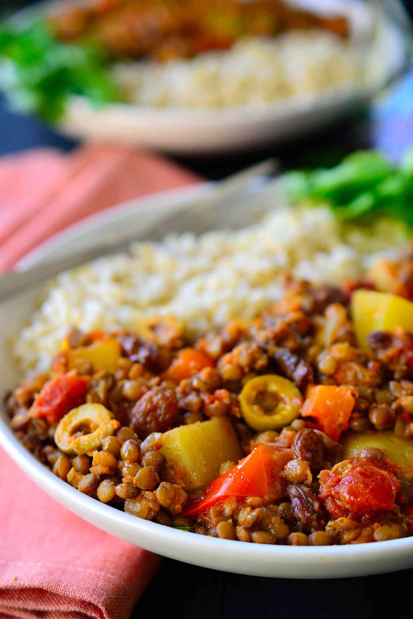 This vegan picadillo recipe is a delicious and colourful Cuban-style dish of spiced lentils, potatoes, tomatoes, olives and raisins. Served with rice, it’s quick and easy to prepare for a weeknight dinner and the warming spices of cinnamon, cumin, cloves and nutmeg make it a comforting and hearty meal for chilly weather. 