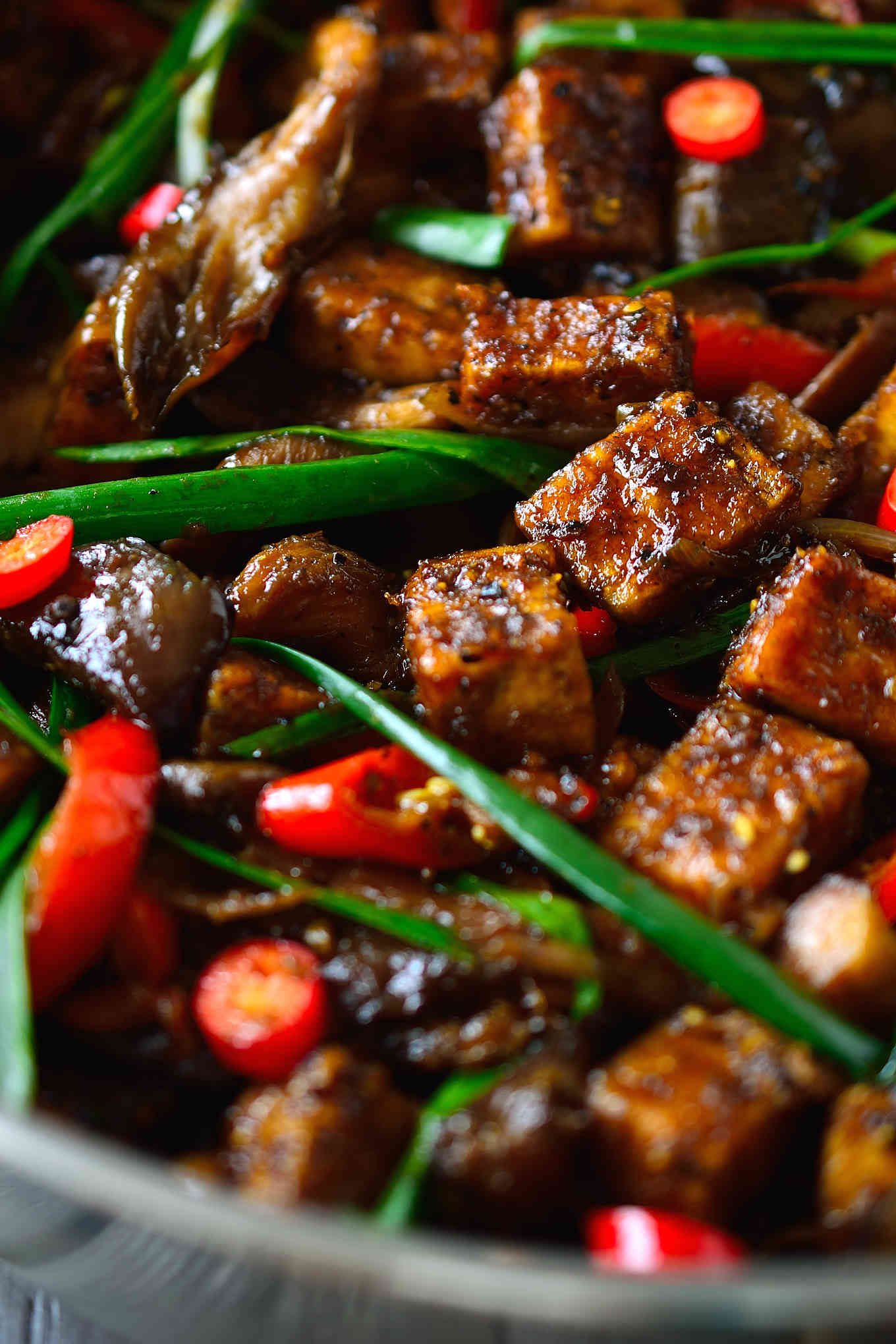 This vegan black pepper tofu recipe is everything you ever wanted tofu to be. It’s crispy on the outside, light and airy on the inside and smothered in a savory, sweet, fiery black pepper sauce that will have you licking your chopsticks. Tossed with meaty oyster mushrooms and creamy pan-fried eggplant served over rice, this easy tofu recipe is a complete meal on one plate.
