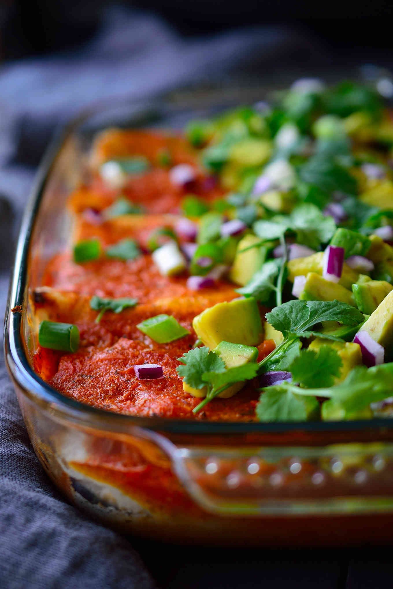 This recipe for pinto bean enchiladas is super hearty with a filling of slow-cooked smoky and spicy pinto beans and spinach, a quick and easy homemade enchilada sauce and topped with creamy avocado, sweet red onion and fresh cilantro. And in case you didn’t notice, these enchiladas are totally vegan, too!