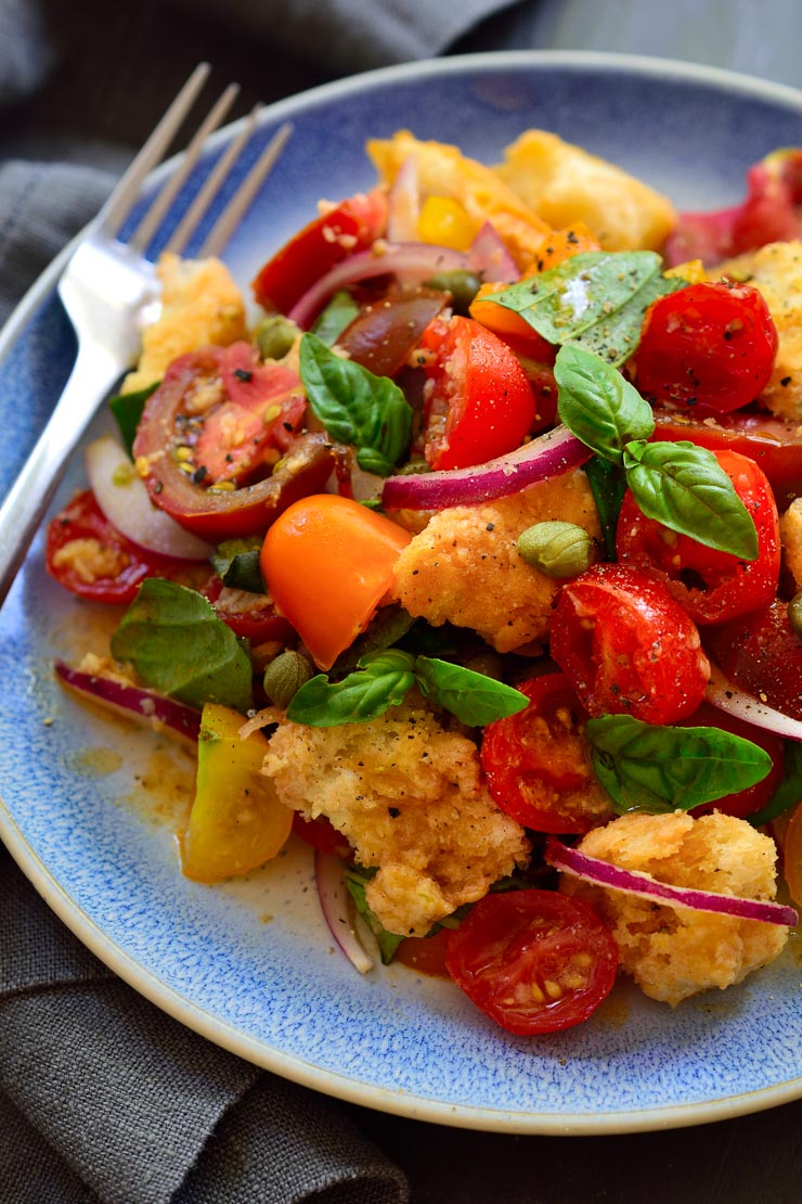 Panzanella is a simple, rustic Italian bread and tomato salad that bursts with flavour despite its humble ingredients. Fresh tomatoes, basil, red onion and day-old bread in a tangy, umami (thanks to an unusual ingredient) vinaigrette are all you need to enjoy this bright and colourful salad!