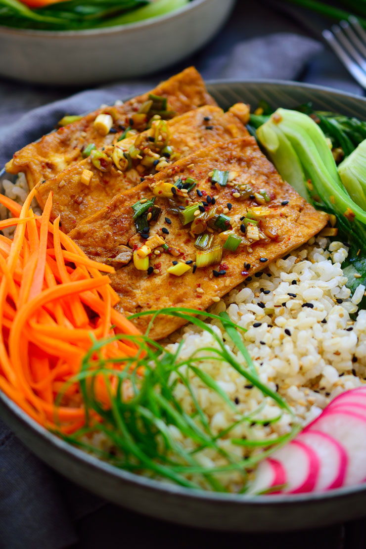 Este Buddha bowl es muy fácil de hacer con tofu picante al estilo coreano, zanahorias encurtidas, pak choi salteado con ajo y rábanos frescos – todo encima de una cama de arroz. Es un plato completo y totalmente vegetariano en solo un bol!