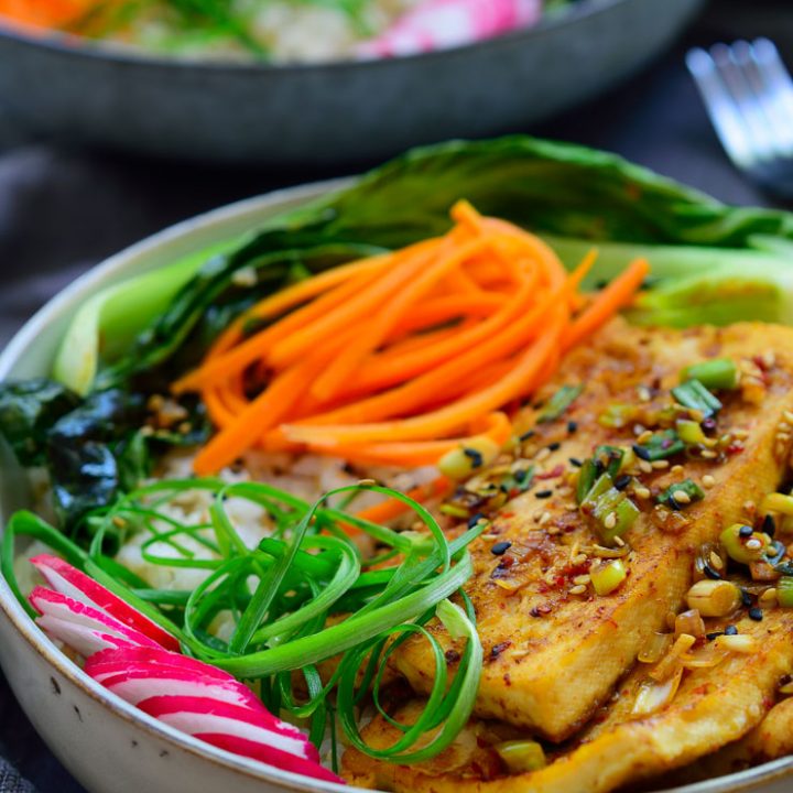 Este Buddha bowl es muy fácil de hacer con tofu picante al estilo coreano, zanahorias encurtidas, pak choi salteado con ajo y rábanos frescos – todo encima de una cama de arroz. Es un plato completo y totalmente vegetariano en solo un bol!