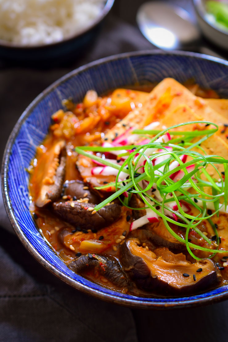 This vegan kimchi stew is quick and easy to prepare, packed with flavour and as spicy as you want it to be. Served with sliced tofu, shiitake mushrooms and rice on the side, it’s a full and hearty meal that can be prepared in less than 30 minutes.