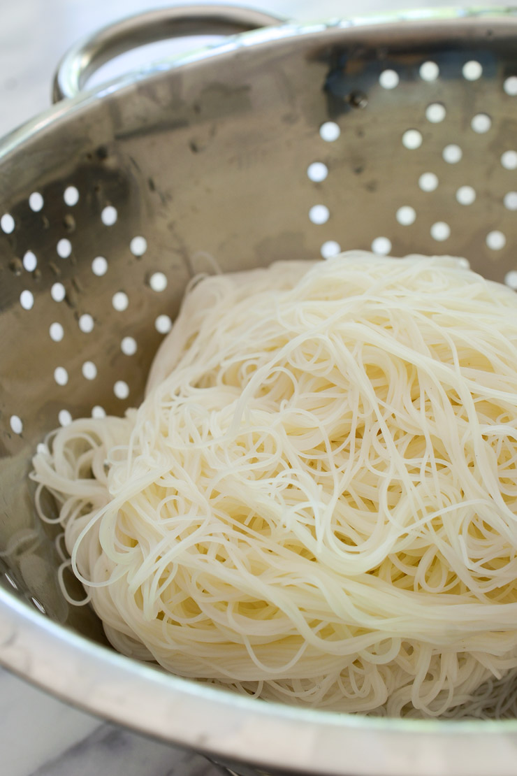 The cooked rice vermicelli noodles in a colander.
