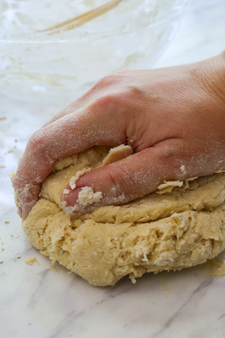 A hand kneading the ball of dough.
